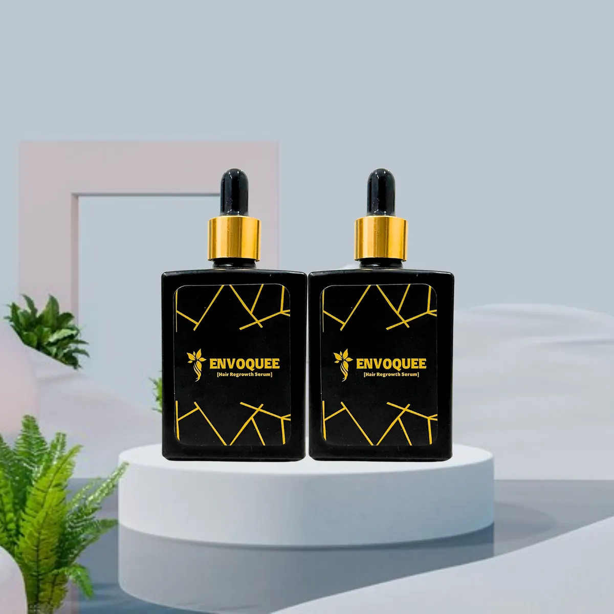 Two Envoquee Hair Regrowth Serum bottles in matte black glass with gold collars